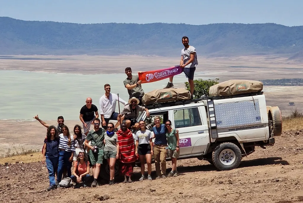 The group around the 4x4 loaded with rooftop tents, overlooking the Ngorongoro crater